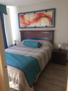 Un dormitorio con una cama con una almohada azul. en Apartamentos Armando, en Santiago