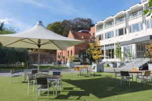 a patio area with chairs, tables and umbrellas at Lincoln Hotel, Sure Hotel Collection by Best Western in Lincoln