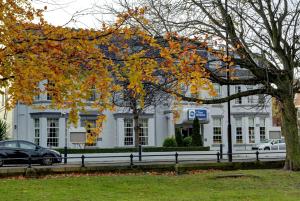 a white house with a tree in front of it at Best Western New Kent Hotel in Newcastle upon Tyne