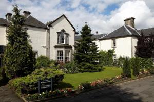 a large white house with a sign in the front yard at Best Western Plus Dunfermline Crossford Keavil House Hotel in Dunfermline