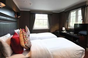 a hotel room with two beds and a television at Best Western Glasgow South Eglinton Arms Hotel in East Kilbride