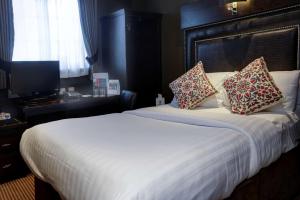 a bedroom with a large bed with two pillows on it at Eglinton Arms Hotel, BW Premier Collection in East Kilbride