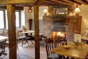 a fireplace in a restaurant with tables and chairs at Old Hunstanton Le Strange Arms Hotel in Hunstanton