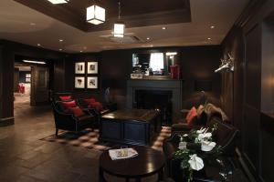 Best Western Eglinton Arms Hotel في إيست كيلبرايد: غرفة معيشة مع أريكة ومدفأة