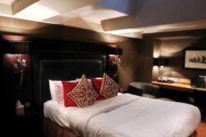 a hotel room with a bed with red pillows at Best Western Glasgow South Eglinton Arms Hotel in East Kilbride +51 photos