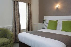a hotel room with a bed and a chair at Best Western Royal Hotel in Saint Helier Jersey