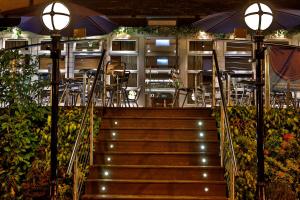 a staircase leading to a restaurant with tables and umbrellas at Best Western Motherwell Centre Moorings Hotel in Motherwell