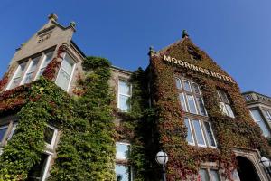 Best Western Motherwell Centre Moorings Hotel في ماذرويل: مبنى مغطى في اللبلاب مع وضع علامة عليه