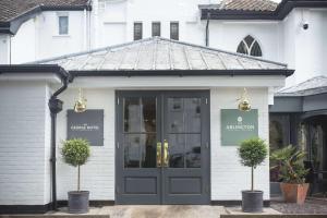 a store front with a door and two potted plants at George Hotel, Best Western Signature Collection in Norwich