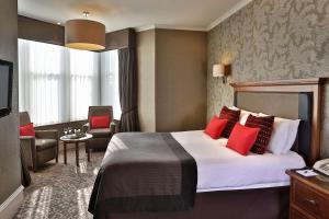 Best Western Motherwell Centre Moorings Hotel في ماذرويل: غرفة فندق بسرير كبير ومخدات حمراء