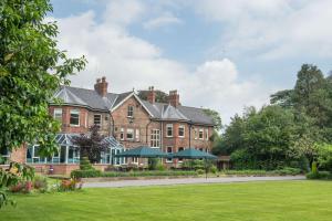 a large brick house with a lawn in front of it at Burn Hall Hotel in Huby