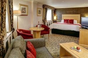 フロッドシャムにあるBest Western Frodsham Forest Hills Hotelのベッドとリビングルームが備わるホテルルームです。