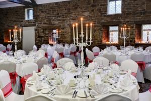 a room with white tables and chairs and chandeliers at Best Western Plus Sheffield Mosborough Hall Hotel in Sheffield