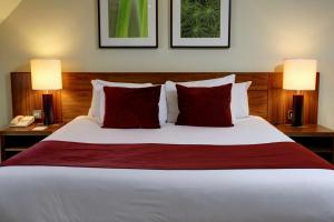 a bedroom with a bed with red pillows and two lamps at Best Western Ship Hotel in Weybridge +55 photos