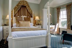 a bedroom with a large bed with a canopy at Best Western Sysonby Knoll Hotel in Melton Mowbray