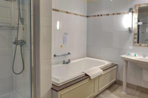 a bathroom with a bath tub and a sink at Best Western Frodsham Forest Hills Hotel in Frodsham