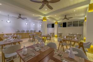 restauracja ze stołami i krzesłami oraz sufitem w obiekcie Dhiguveli Maldives w mieście Dhigurah