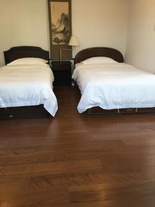 two beds in a room with wooden floors at Kyoto LanLan in Kyoto +22 photos