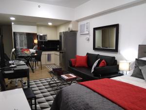 Cet appartement comprend une chambre avec un lit, un salon et une cuisine. dans l'établissement Abreeza Studio by Lustra, à Davao