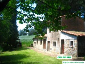 Agriturismo Villa Giada في Valentano: مبنى حجري قديم مع حقل في الخلفية
