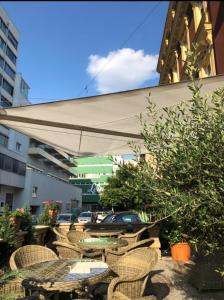 a patio area with chairs, tables and umbrellas at Best Western Hotel Strasser in Graz
