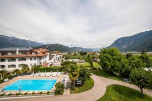 an aerial view of a resort with a swimming pool and mountains at Hotel Markushof in Auer