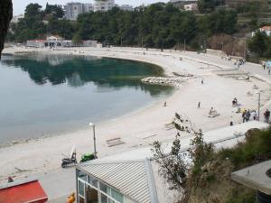 a beach with people on the sand and water at Apartments Beautiful Sandy Beach in Split
