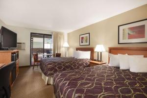 a hotel room with two beds and a flat screen tv at Super 8 by Wyndham Williston ND in Williston +21 photos
