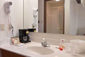 a bathroom with a sink with a coffee maker on it at Super 8 by Wyndham Crawfordsville in Crawfordsville +7 photos