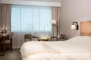 a hotel room with a bed and a table and chairs at Howard Johnson Plaza Buenos Aires in Buenos Aires