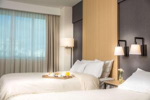 a hotel room with two beds and a window at Howard Johnson Plaza Buenos Aires in Buenos Aires