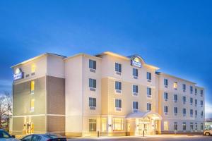 een hotelgebouw met auto's geparkeerd op een parkeerplaats bij Days Inn & Suites by Wyndham Kearney NE in Kearney
