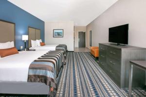 ein Hotelzimmer mit 2 Betten und einem Flachbild-TV in der Unterkunft Wingate by Wyndham Corpus Christi in Corpus Christi