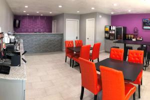 a dining room with a table and orange chairs at Super 8 by Wyndham Sonora in Sonora +8 photos