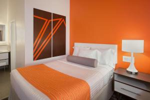 Un dormitorio con una cama con una pared naranja. en Howard Johnson by Wyndham Toms River, en Toms River