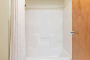 y baño con bañera y cortina de ducha. en Super 8 by Wyndham Burleson Fort Worth Area, en Burleson