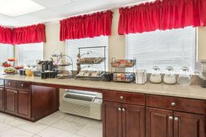 a kitchen with a large counter with red curtains at Ramada by Wyndham Pelham in Pelham