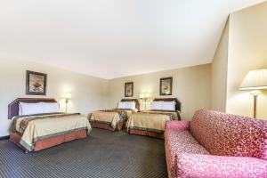 a hotel room with two beds and a couch at Super 8 by Wyndham Burleson Fort Worth Area in Burleson