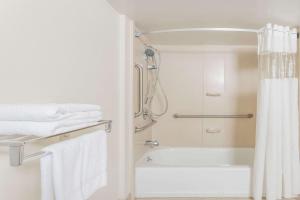 uma casa de banho com um chuveiro e uma banheira em Days Inn by Wyndham Camp Springs Andrews AFB em Camp Springs
