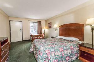 a hotel room with a bed and a desk at Days Inn by Wyndham Camp Springs Andrews AFB in Camp Springs