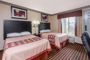 a hotel room with two beds and a window at Super 8 by Wyndham Old Saybrook in Old Saybrook