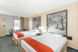 a hotel room with two beds and a desk at Super 8 by Wyndham Adel GA I-75 in Adel +16 photos