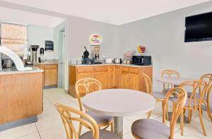 a kitchen and dining room with tables and chairs at Super 8 by Wyndham Athens in Athens