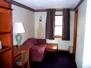 a living room with a couch and a table and a window at Wesley Inn & Suites in Middletown