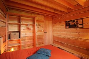 Cabaña de madera con cama y ventana en Open Range, en Château-Chervix