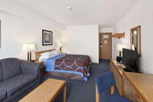 um quarto de hotel com uma cama e um sofá em Super 8 by Wyndham Swift Current em Swift Current