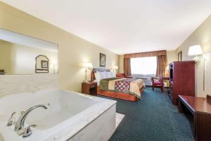 a hotel room with a tub and a bed at Super 8 by Wyndham Burleson Fort Worth Area in Burleson