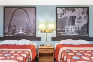 a hotel room with two beds and the gateway arch at Super 8 by Wyndham Carthage in Carthage
