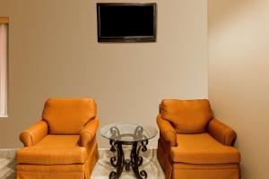 Duas cadeiras e uma mesa num quarto com televisão em Super 8 by Wyndham Frankfort IN em Frankfort