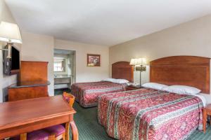 a hotel room with two beds and a table at Days Inn by Wyndham Camp Springs Andrews AFB in Camp Springs